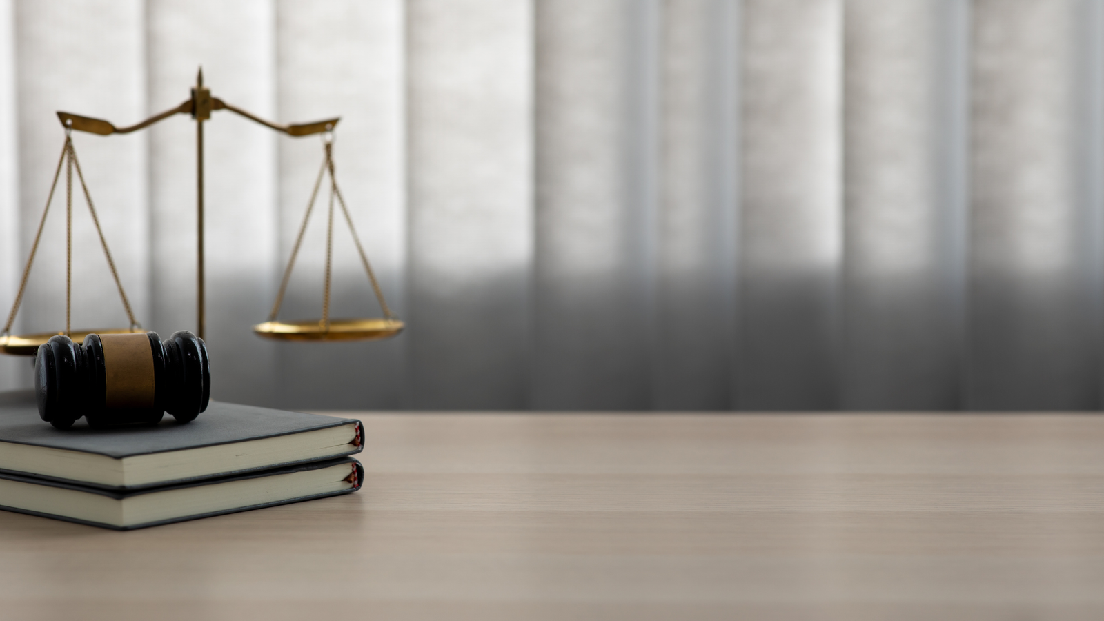 Imagem de uma mesa que tem um malhete e ao lado uma balança da justiça.
