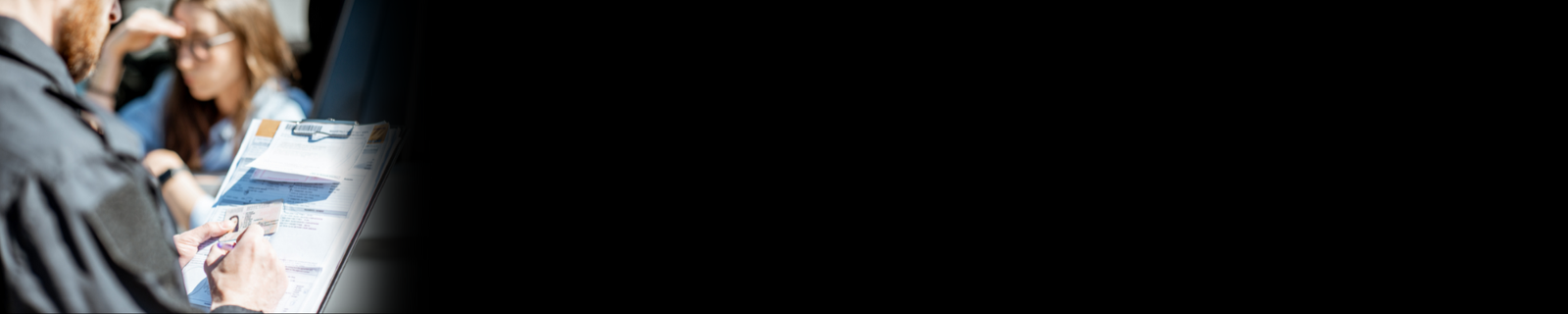 Imagem de um agente de trânsito, multando uma mulher.